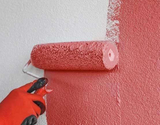Persona aplicando impermeabilizante en paredes